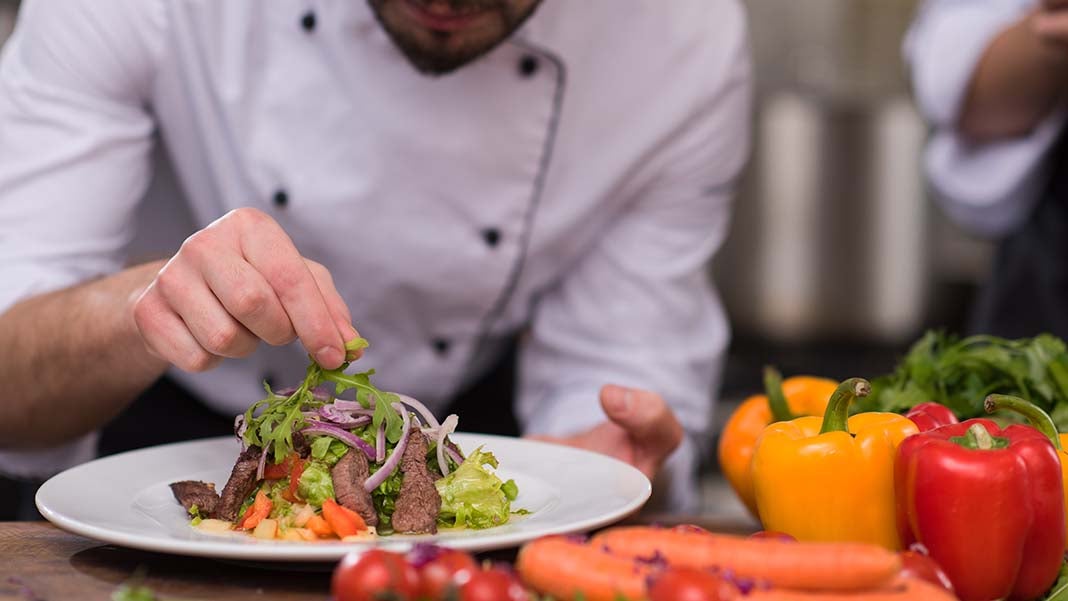 chef placing garnish on food