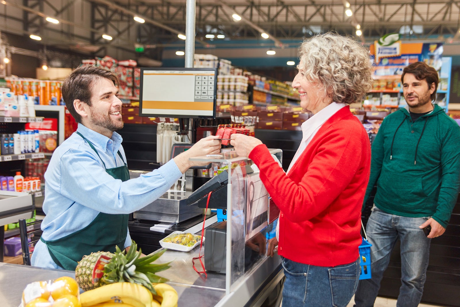 Customer pays by cashier or customer card at cashier supermarket checkout