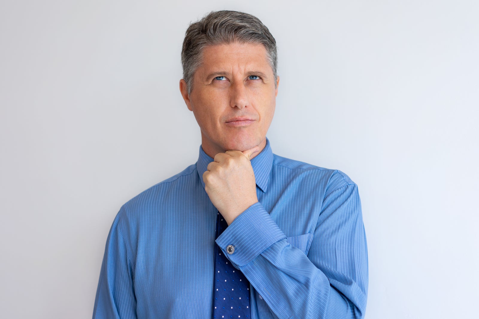 Pensive business leader thinking over new strategy. Middle aged Caucasian man in tie touching and looking up with thoughtful face. Thinking concept