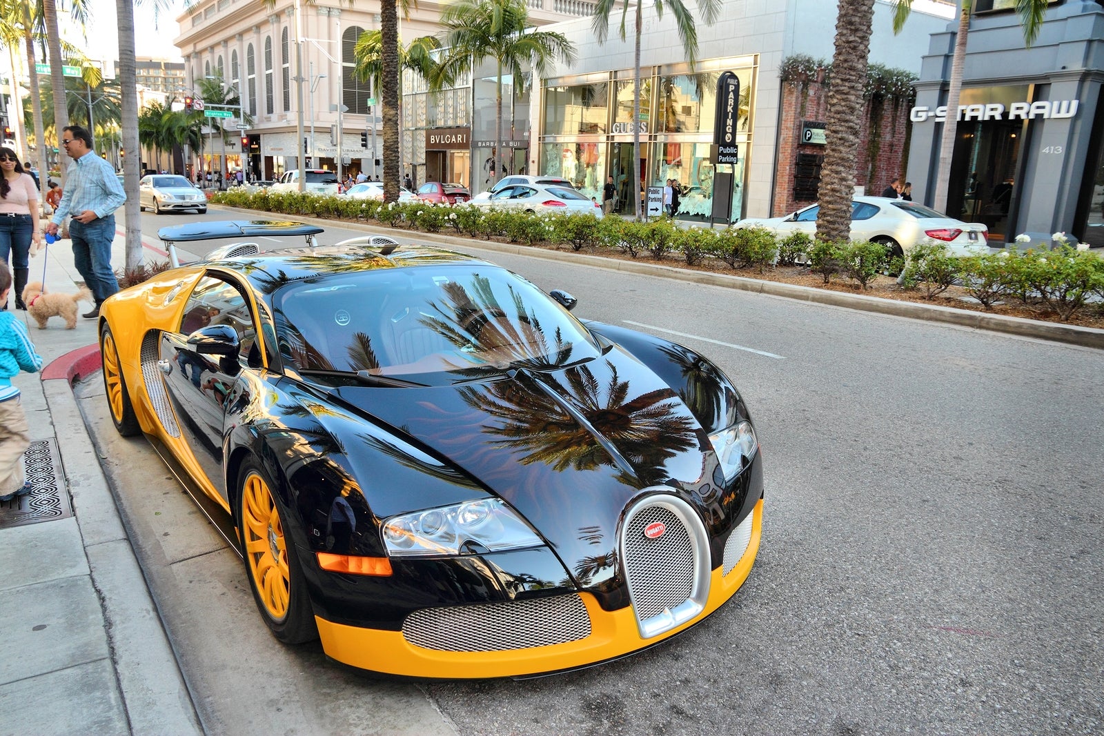LOS ANGELES USA - APRIL 5 2014: People walk by Bugatti Veyron supercar parked in Beverly Hills Los Angeles. Beverly Hills is a district of upscale shopping and rich celebrities.