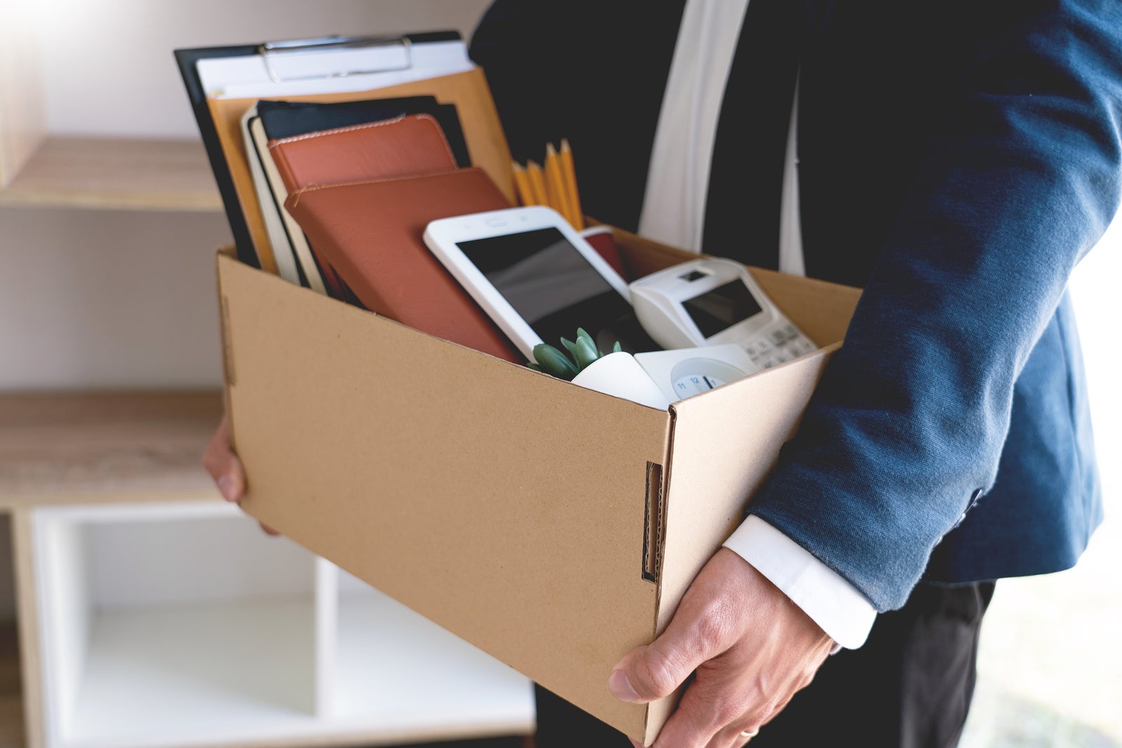 Sad Fired Young Employee businessmen hold boxes including pot plant and documents for personal belongings unemployment, resigned concept