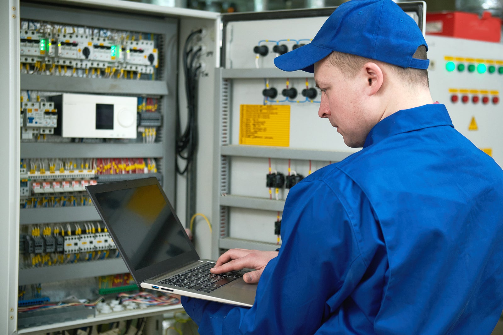 Electrician measures electrical paramenters with tester multimeter equipment at electrical fusebox or switch box