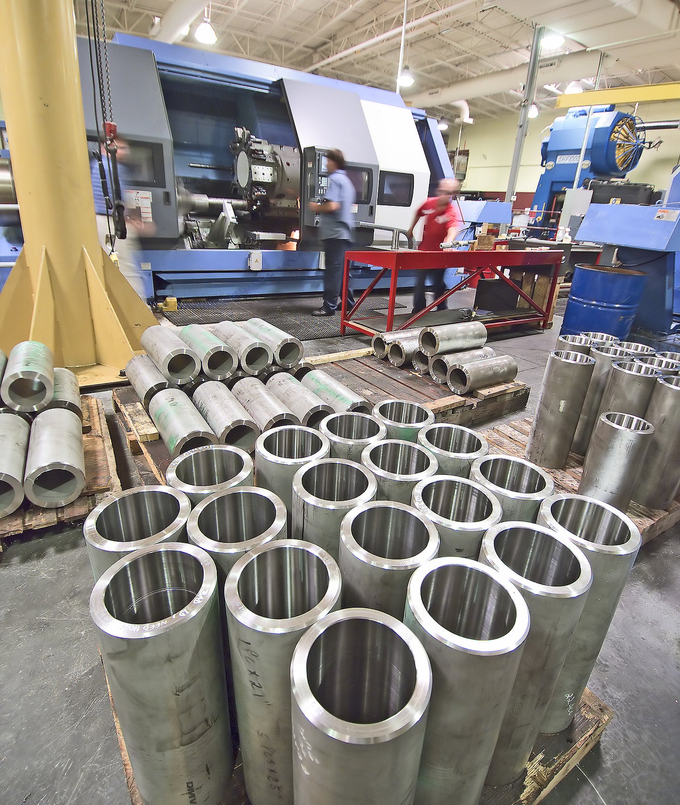 Big lathe cutting stainless steel tubes with workers in the background
** Note: Slight blurriness, best at smaller sizes