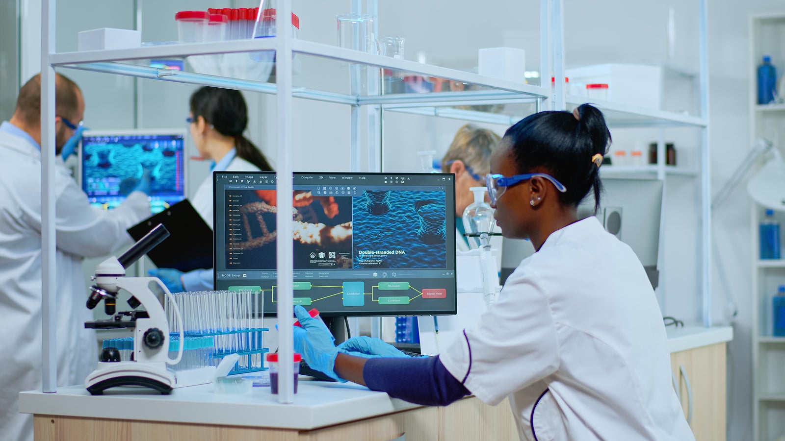 Black woman researcher carrying out scientific research in equipped lab. Multiethnic team examining virus evolution using high tech for scientific research of treatment development against covid19