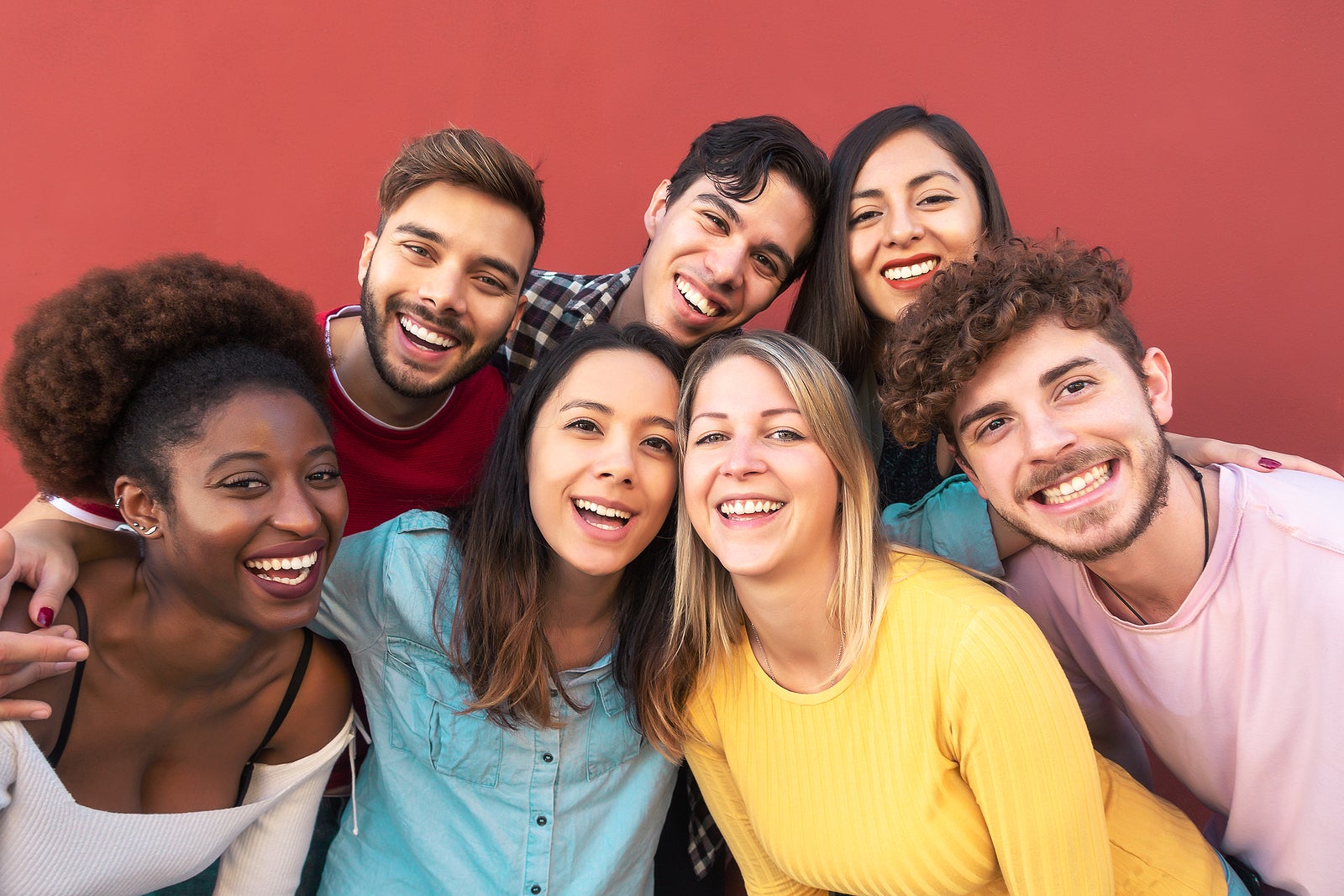 Group multiracial people having fun outdoor - Happy mixed race friends sharing time together - Youth millennial generation and multiethnic teenagers lifestyle concept - Red Background