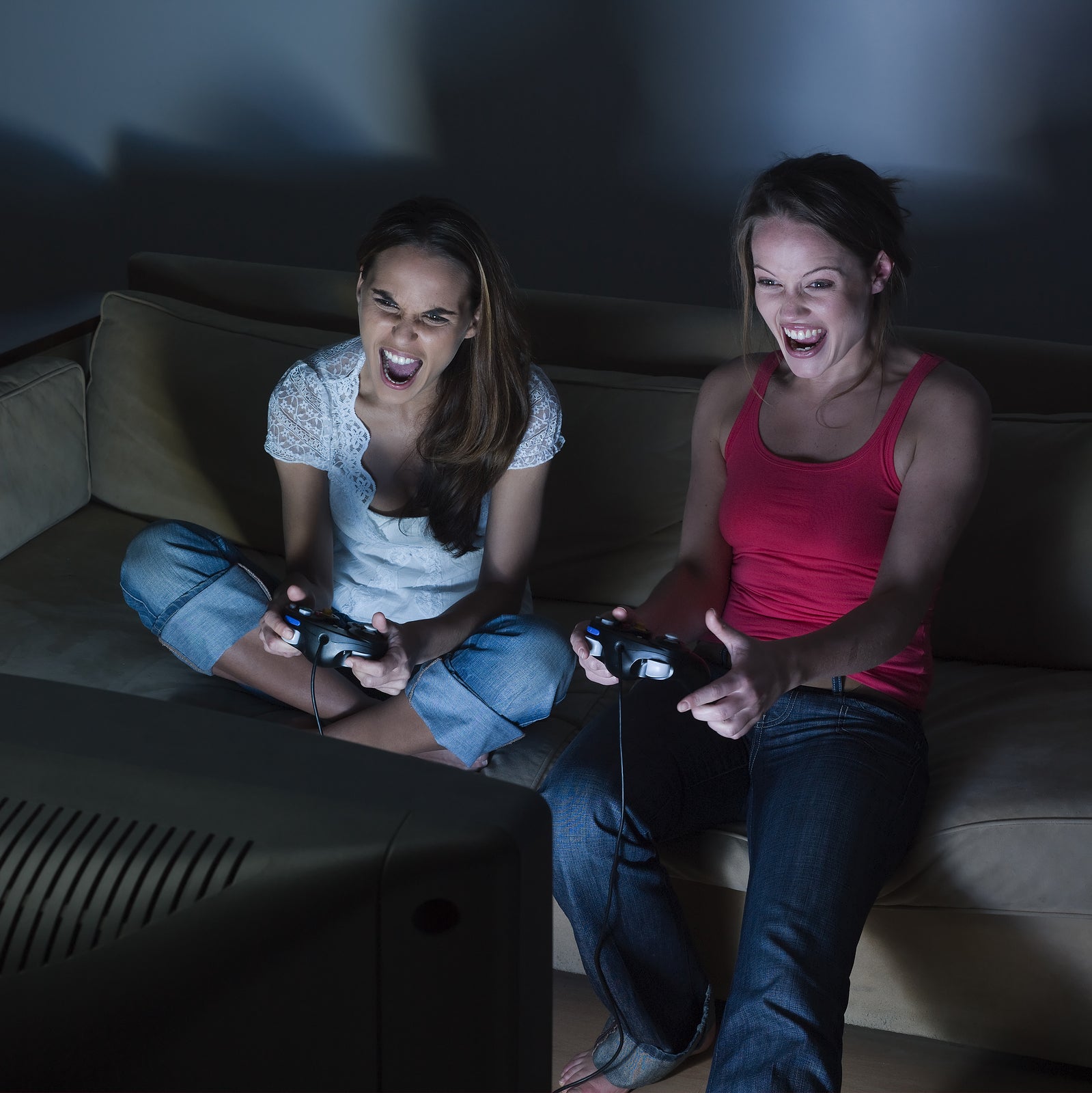 pictures in a living room of two young girls sitting on a couch playing video game