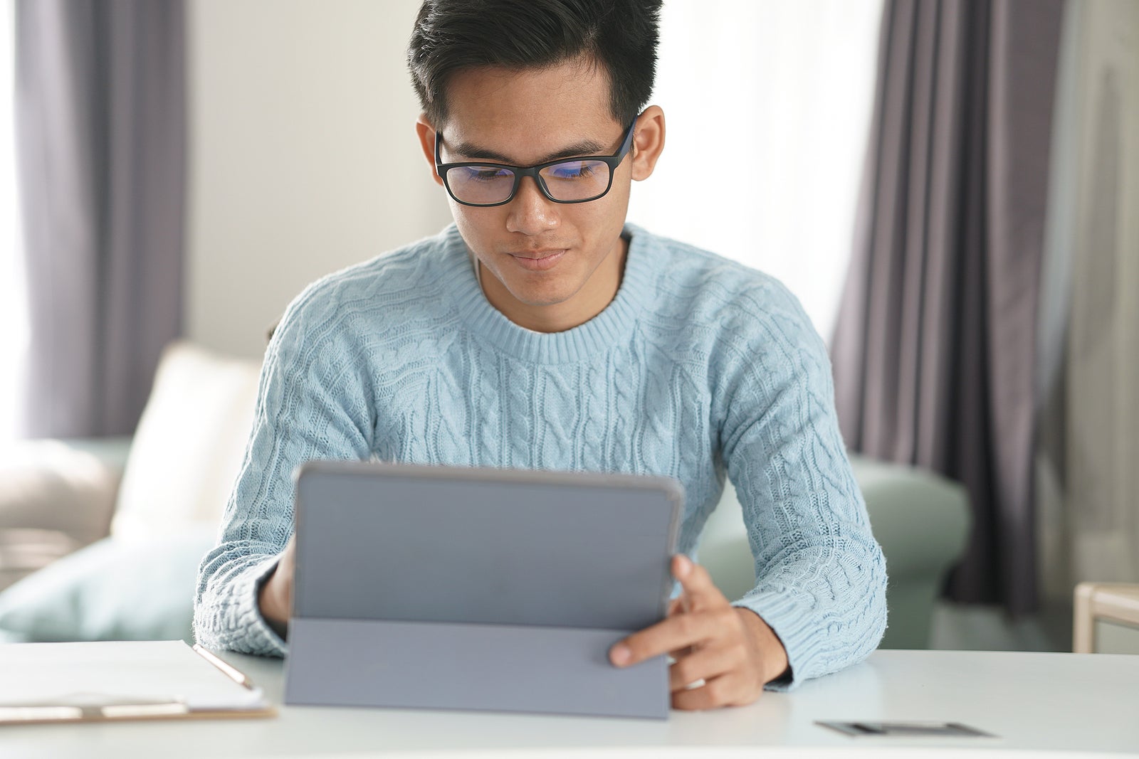 asian young teenage student man teenager entrepreneur working with tablet studying learning online at home. e-learning webinar meeting. social distance in covid pandemic