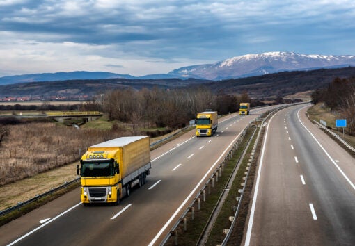 Fleet Of Yellow Trucks In Line As A Convoy At A Rural Countrysid