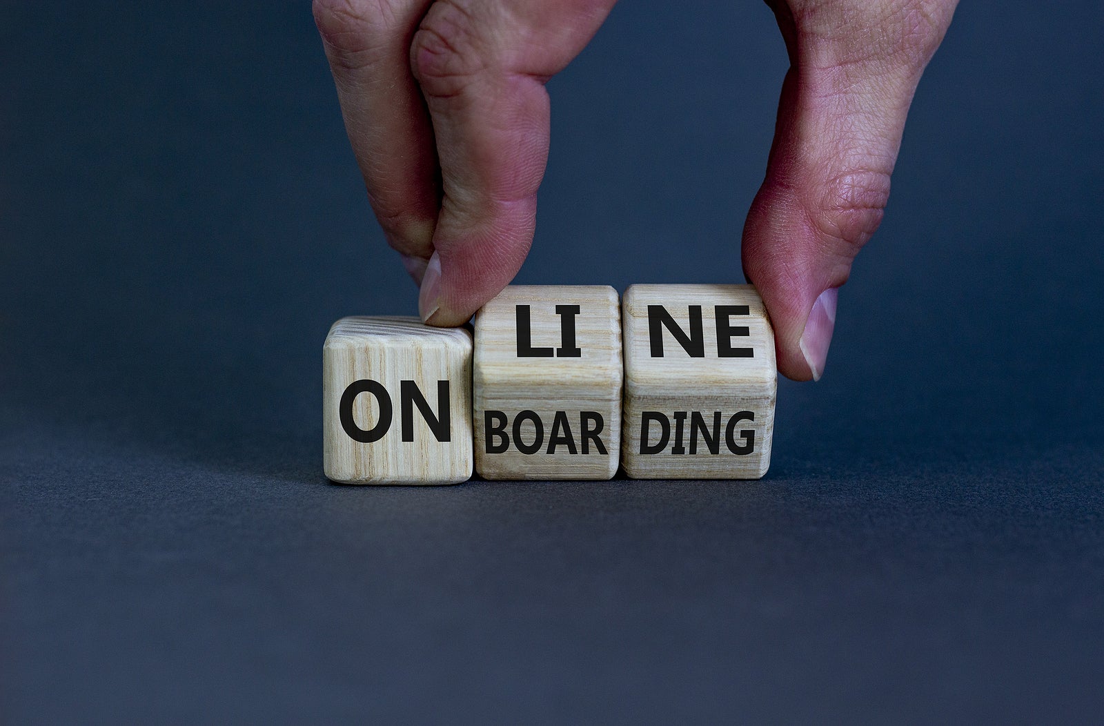 Online onboarding symbol. Businessman turns wooden cubes with words 'online onboarding'. Beautiful yellow table, white background, copy space. Business, online onboarding concept.