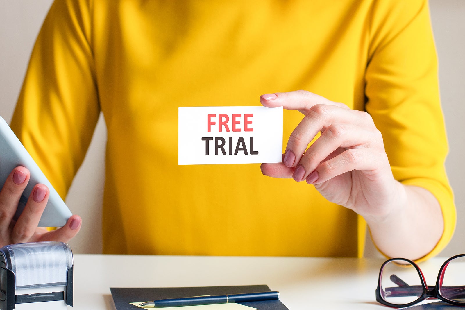 free trial written on a paper card in woman hand, concept