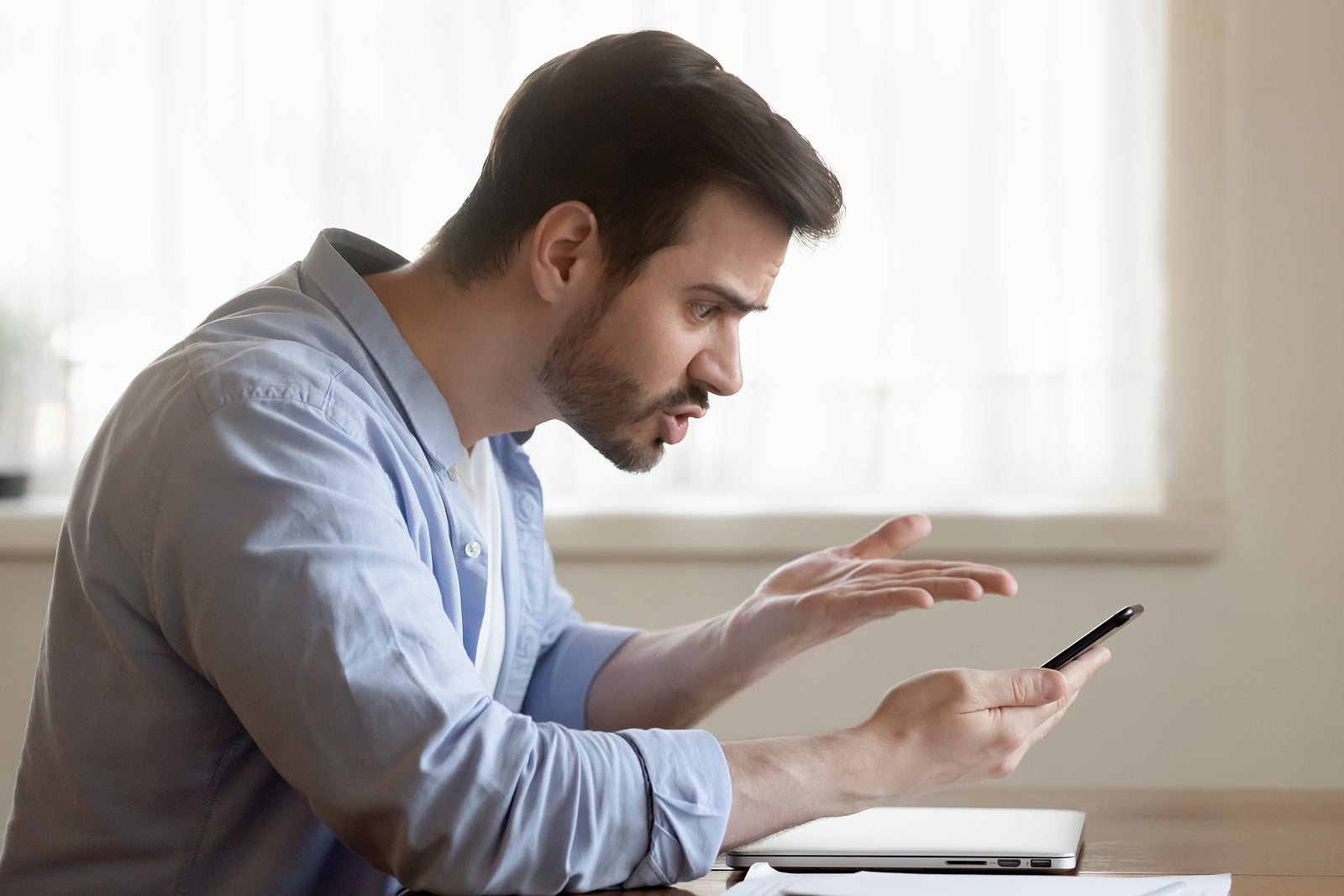 Angry male brawling by phone with client support of bank