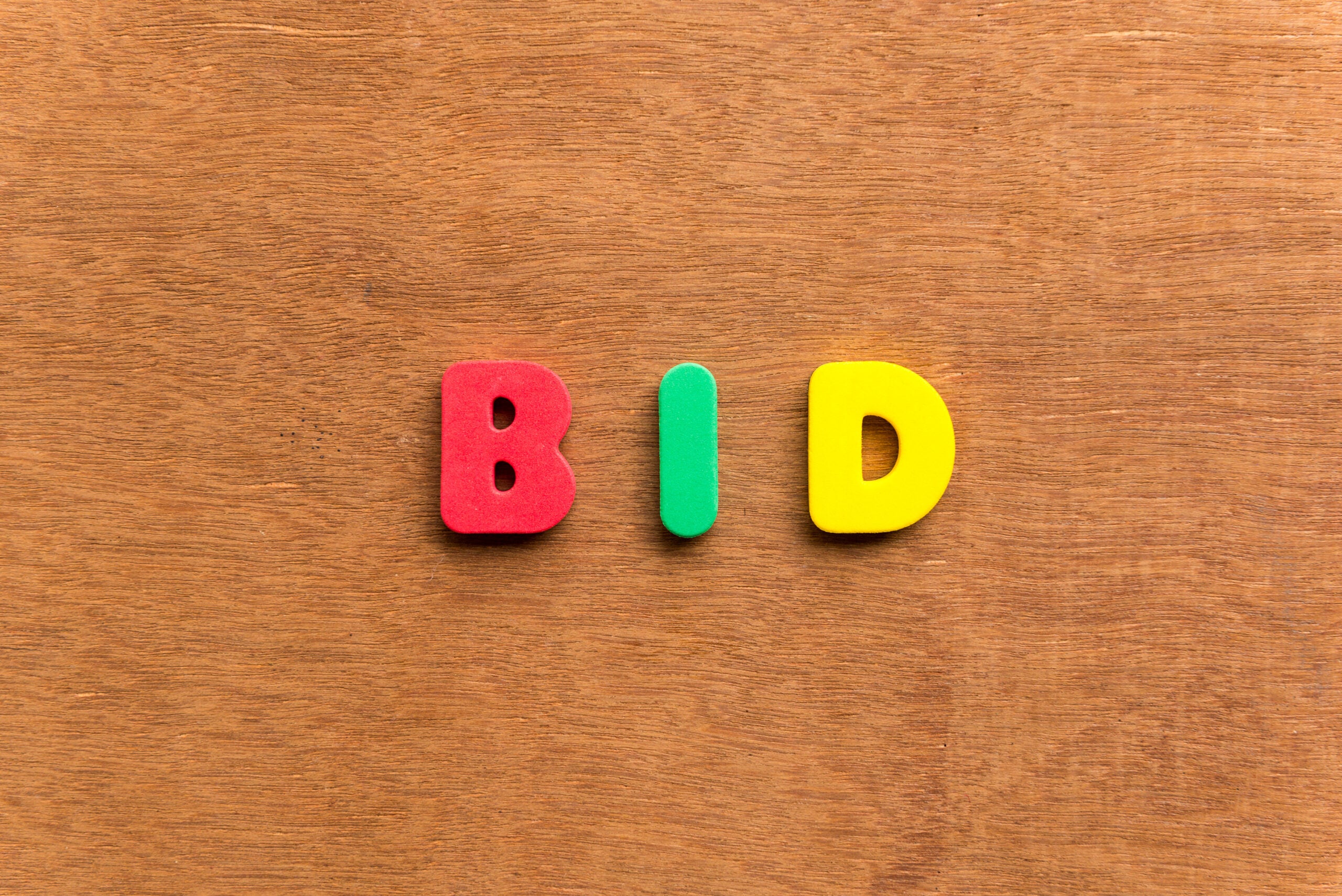 bid colorful word on the wooden background