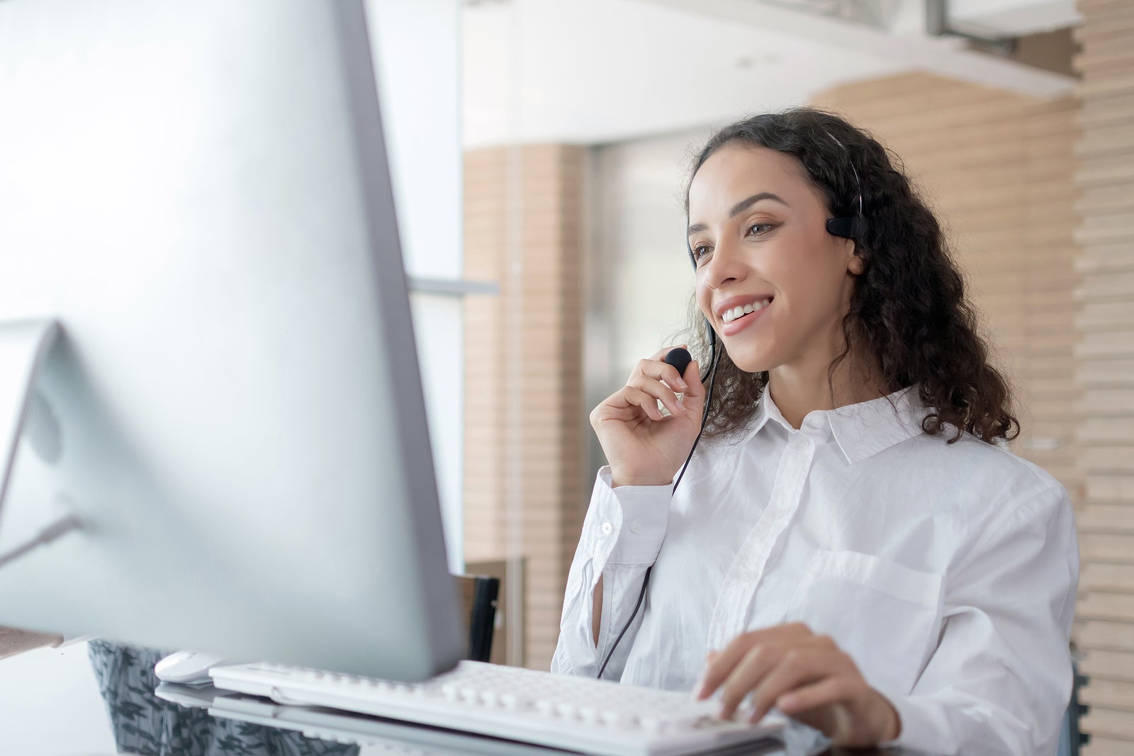 Hotline. happy young caucasian female call center customer support executive with headset working in office, education online, customer support service, call center, phone operator, video call concept