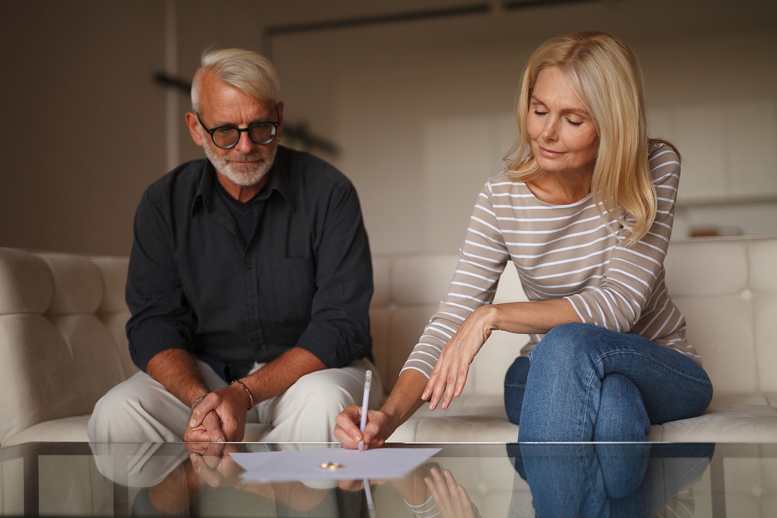 Mature couple signing divorce document. Senior family separation, problems between husband and wife. Marriage contract.