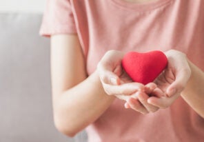 a woman holding a fabric heart