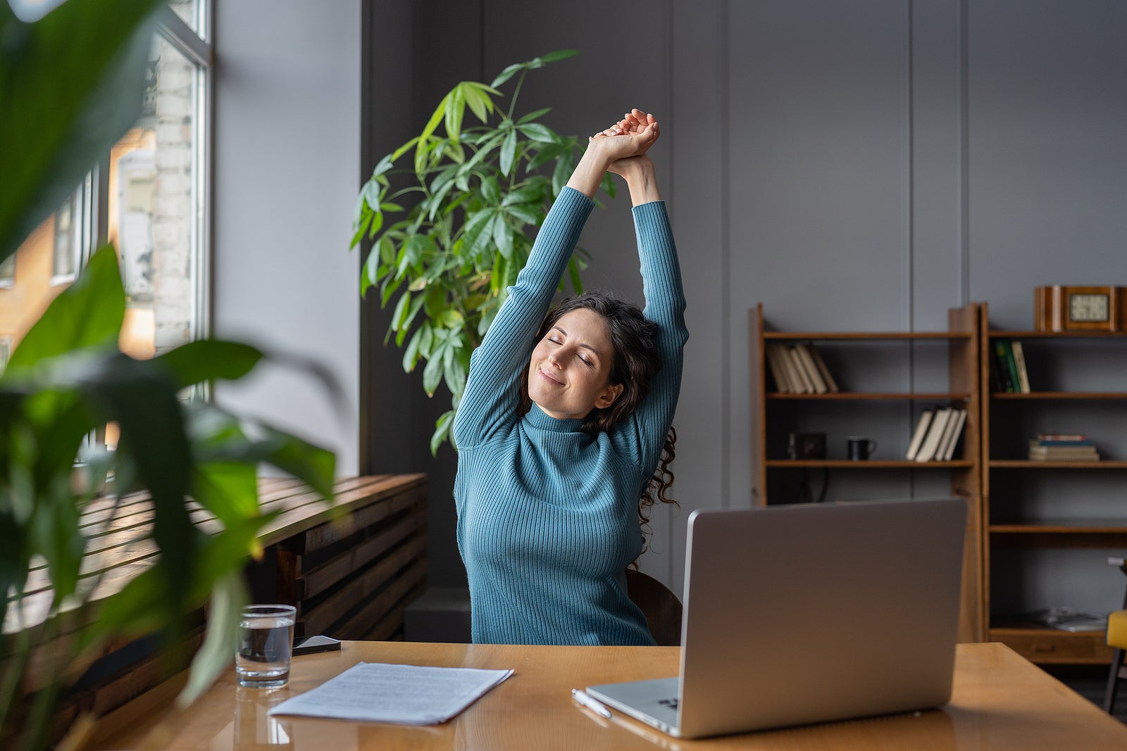 a happy business woman stretching at her desk