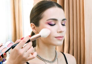 a makeup artist working with a model