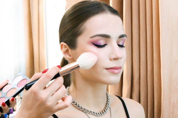 a makeup artist working with a model