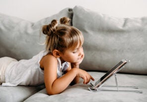 a child using a tablet on the couch