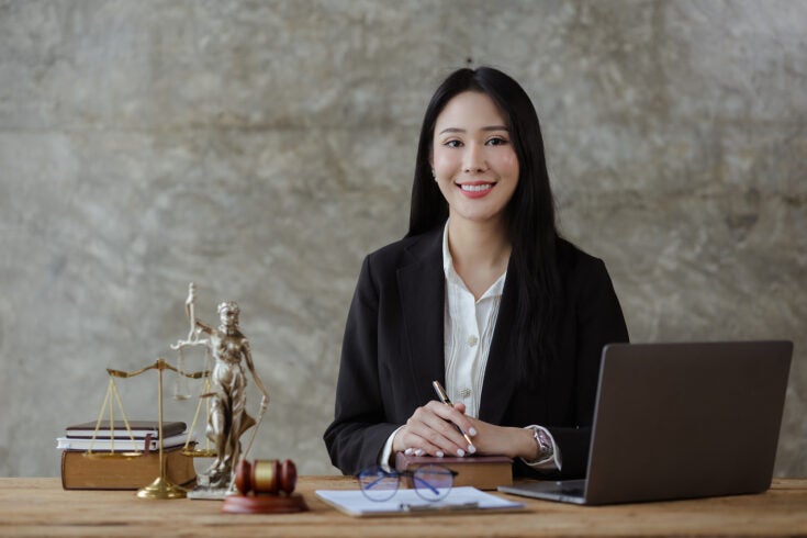 a law firm business owner smiling proudly behind a desk