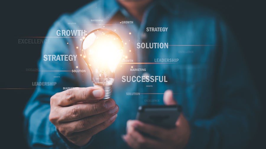 businessman holding a lit lightbulb