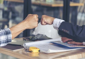 a business owner and their employee fist bumping