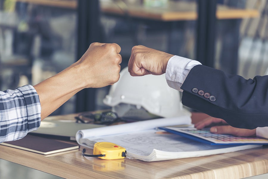 a business owner and their employee fist bumping