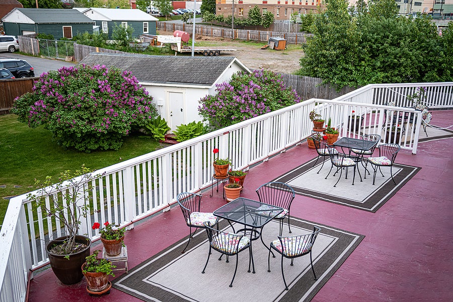 A backyard deck with tables and chairs at an Airbnb in Anchorage Alaska.