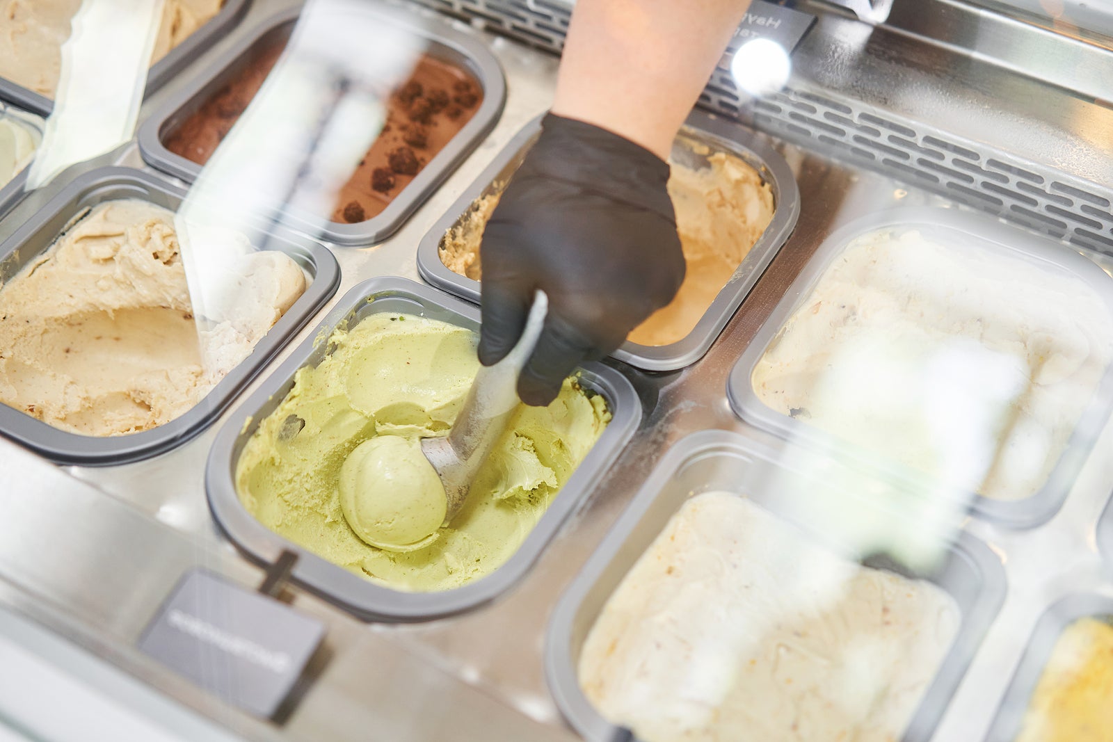 An ice cream vendor makes an ice cream ball. Flavors various ice cream in Rome, Italy. Italian gelateria. Natural fresh ice cream.