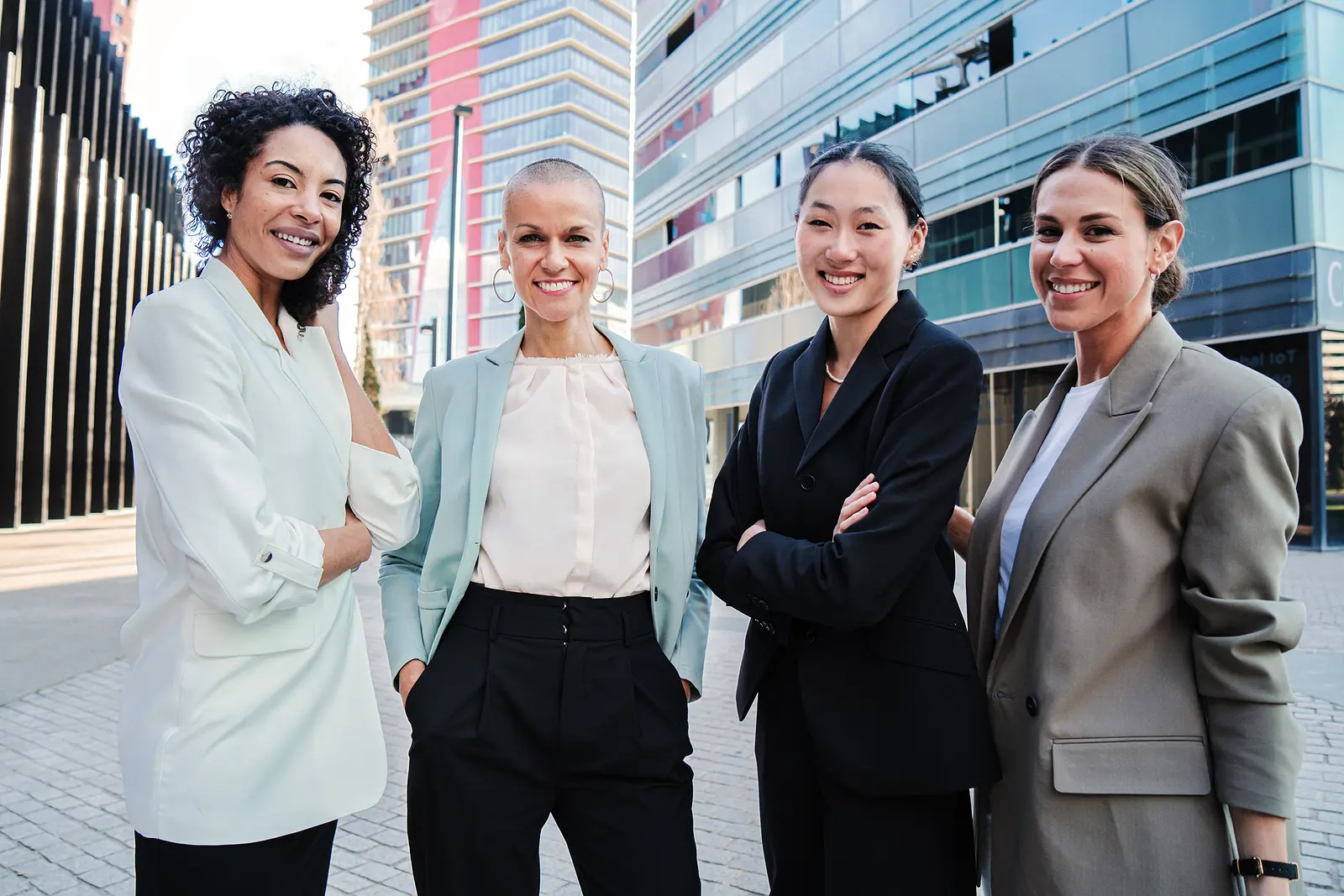Group of good looking business women standing at workplace and posing for the portrait with successful expression. Empowered and proud female executive colleagues looking at camera with formal suit