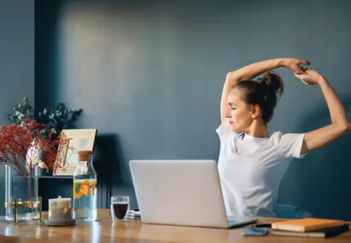 a woman stretching at her desk