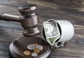 a law gavel and a dollar bill emphasizing the financial burdens of lawsuits
