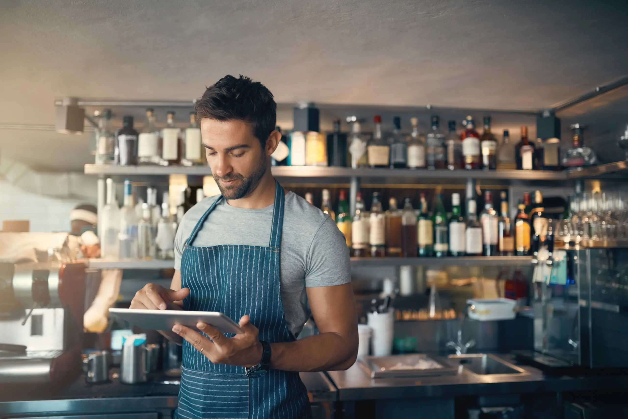 Man in restaurant, tablet and inventory check, small business and entrepreneur in hospitality industry. Male owner, scroll and cafe franchise, digital admin and stock taking with connectivity.