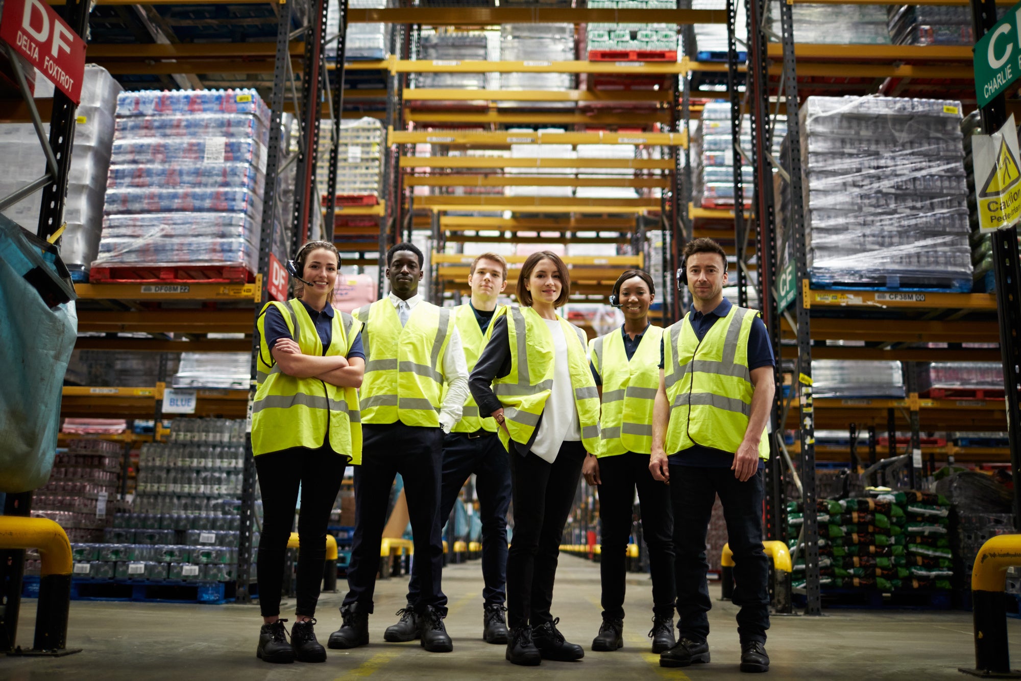 Group portrait of staff at distribution warehouse, low angle
