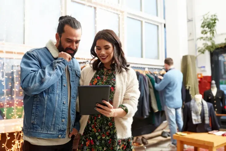 a small business owner of a clothing store using technology to help a customer