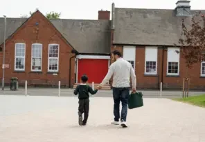 A father and his daughter walking from daycare