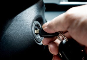 a hand turning the key in a car