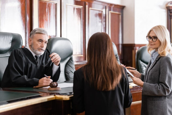 a judge listens to two lawyers