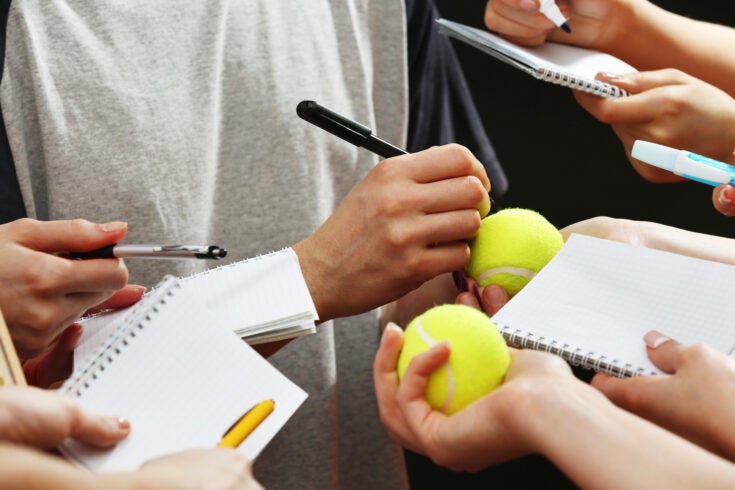 an athlete signing autographs