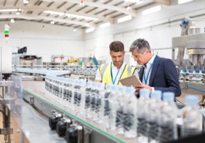 a Supervisor and manager watching plastic bottles on conveyor belt