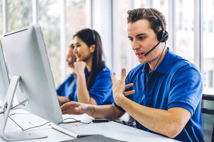 A Group of happy call center employees smiling and providing helpful service