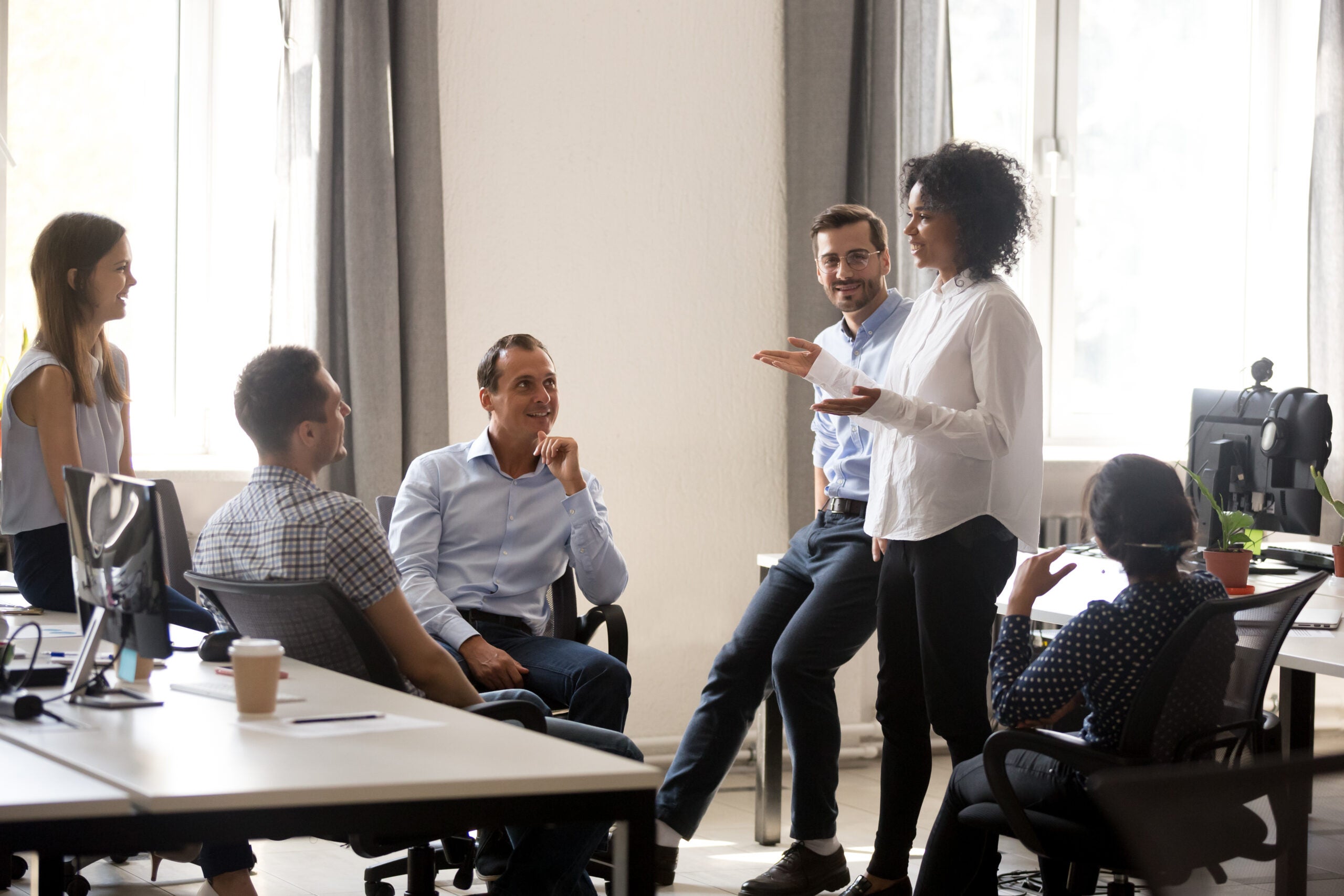 a team leader standing and smiling during a meeting