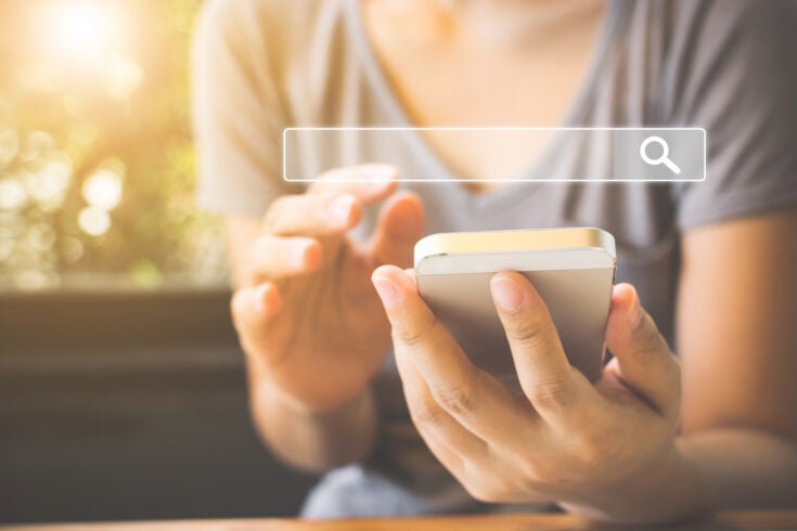 a person using their mobile phone to perform an internet search