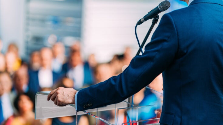 a person giving a speech from a podium