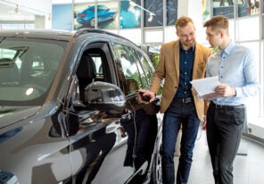 a car salesperson showing a customer a vehicle