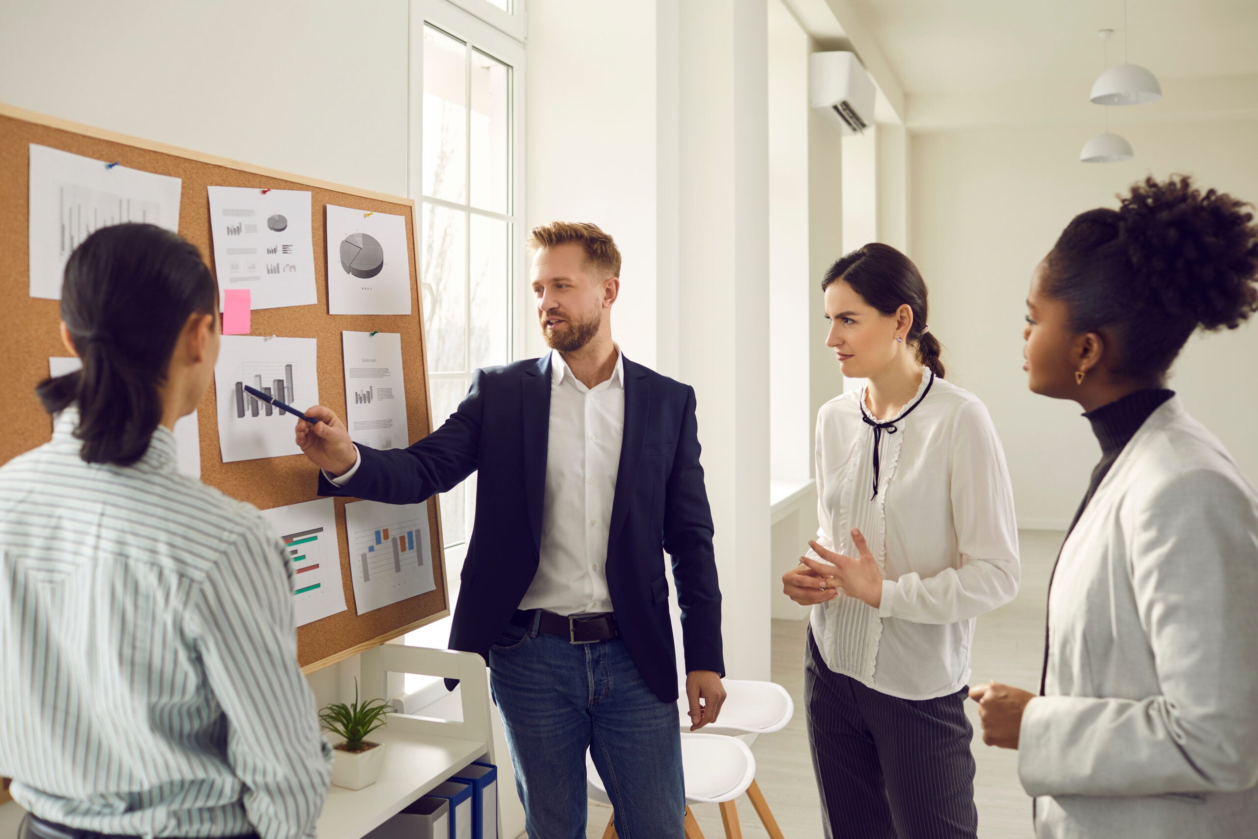 a team member pointing to a graph as other team members look on