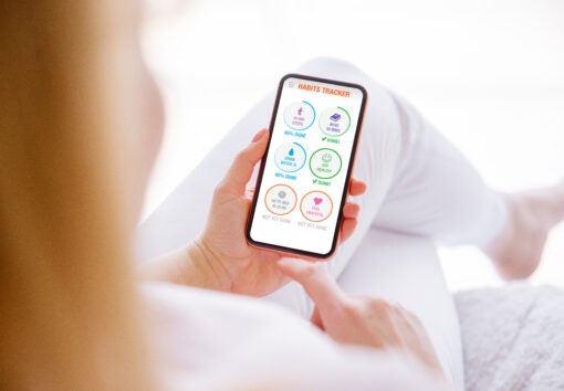 Woman using habits tracker app on mobile phone