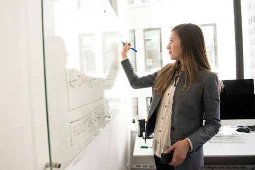 Women in business suit writing on a white board