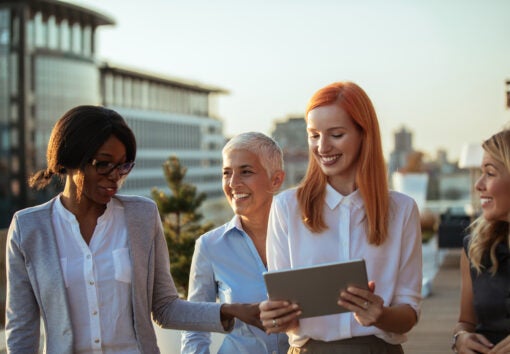 A group of four beautiful professional women hanging out on the rooftop.