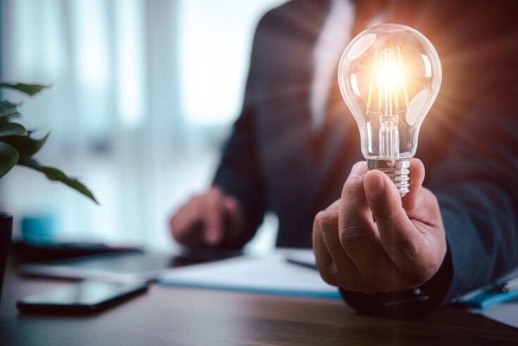 businessman hand holding light bulb with finance document and tool,concept of New ideas for business and fonance.